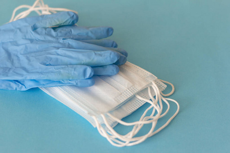 桌上放着一副乳胶医用手套和抗病毒医用口罩.照片