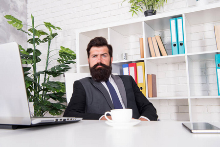 帅哥老板坐在办公室喝咖啡.舒适的工作空间.