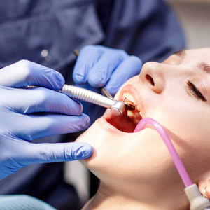 牙科医生在门诊为年轻女性患者治疗牙齿。
