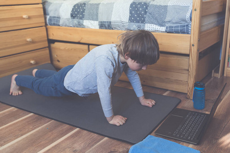 在卧室里做在线瑜伽的男孩