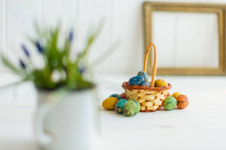 彩色复活节彩蛋放在白色木制背景的篮子里