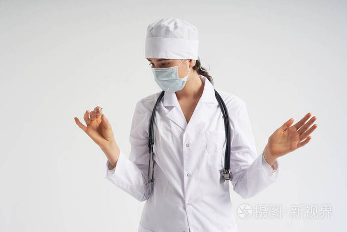 doctorwearingfacemasklookingatmeasurementonmedicaltherm
