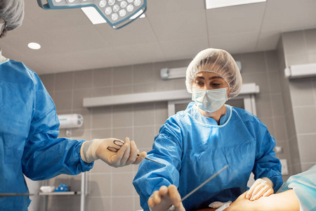 医生们戴着防护面具和实验服的照片在重症监护室集中工作。复苏科，救命，肺炎，Covid 19。