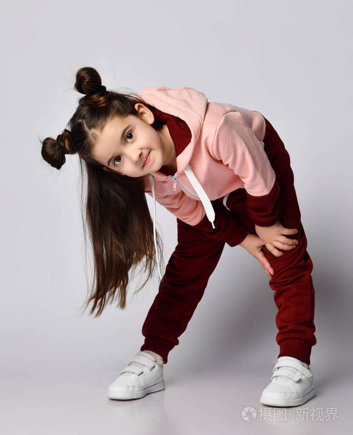 好奇的小女孩一头黑发包着两种颜色的粉棕色运动服正弯腰偷看镜头