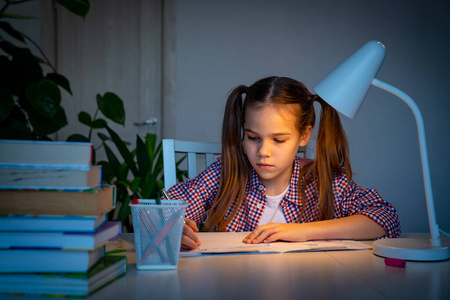 晚上女孩做作业,在家学习.照片