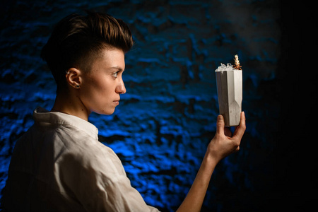 女孩的侧脸,手里拿着装有冷饮的陶瓷玻璃,看着它.照片