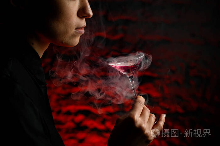 特写的侧面照片女孩的脸她手里拿着烟熏的马提尼酒杯