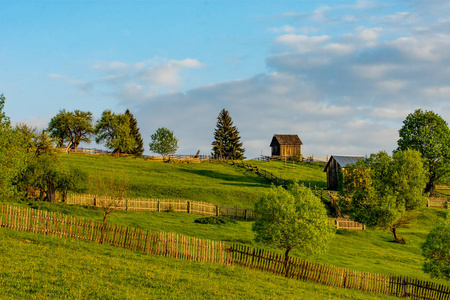 天空多云的绿色草地上的家庭农场