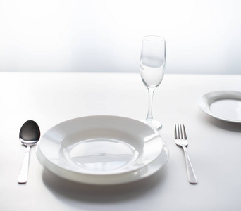 餐桌上的餐具，在空荡荡的餐厅靠窗供应。作为在流感大流行期间关闭公共场所和餐馆的概念。