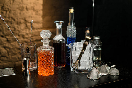 酒吧柜台上摆放着不同的酒瓶,玻璃杯和其他酒吧设备.照片
