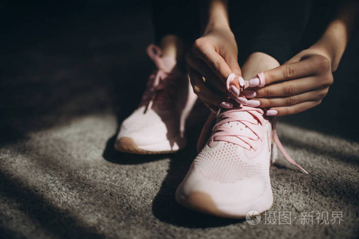在运动鞋上系鞋带的年轻女子