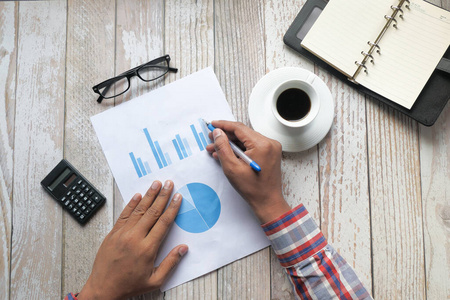 businessman analyzing financial chart on paper 