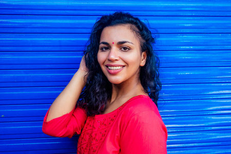 阿拉宾迷人美丽快乐的年轻拉丁西班牙裔妇女,前额有柚木宾迪微笑,蓝色