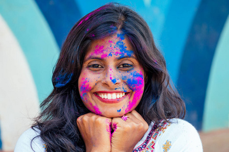 胡里色彩节。快乐的印度女孩的霍利色彩肖像。雪白的笑容和完美的发型