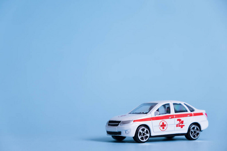 蓝色背景的救护车。紧急医疗服务。玩具医疗车模型。