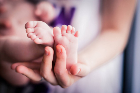 婴儿的脚在母亲的手特写。