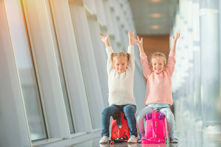 可爱的小女孩在机场拿着行李等着登机