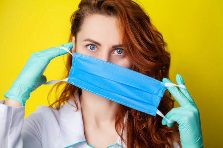 鼻病毒妇女拿着口罩捂住口鼻,以防黄色背景上的病毒.照片
