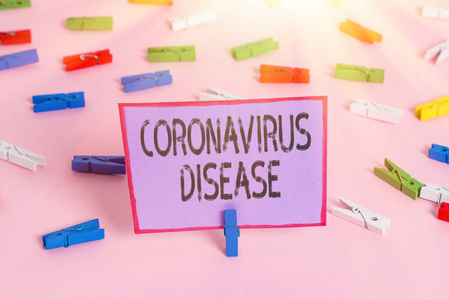 显示冠状病毒病的笔记。商业照片展示被定义为疾病引起的新型病毒SARSCoV2彩色衣夹纸空提示粉红色地板办公室别针。
