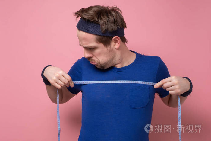 用厘米线测量身体的人他看起来很惊讶因为他没有看到训练的结果