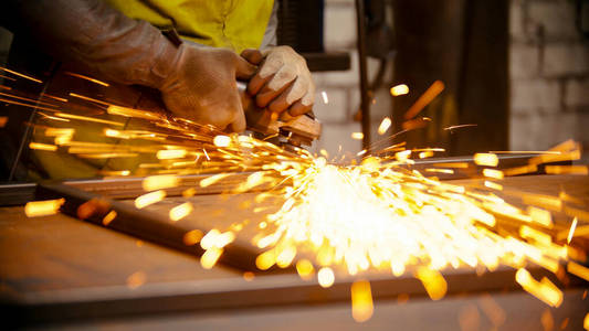 打磨金属框架接缝的工人——金属上会有明亮的火花照片