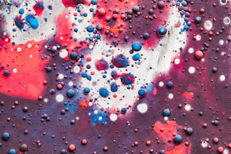  Color drops floating in oil and water over a colorful undergrou