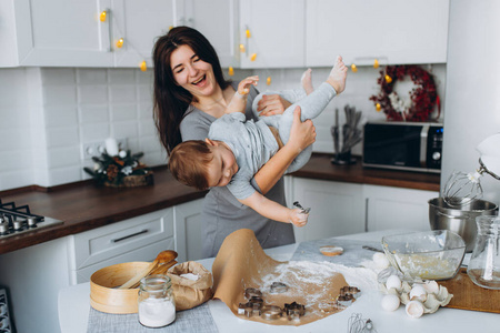 在厨房里度过快乐的家庭时光。妈妈和她的儿子在玩游戏。