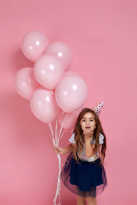 小女孩用粉红色的气球庆祝