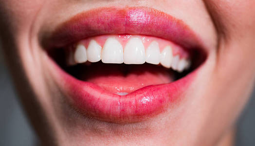 微笑牙齿。笑着的女人嘴上长着大牙齿。健康洁白的牙齿。特写微笑与白色健康牙齿。