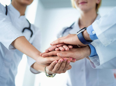 许多快乐的医生把双手叠在一起作为团队的动力