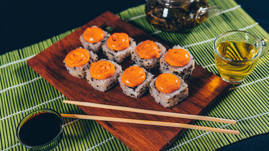 黑色背景的切纸板上美味寿司卷的特写镜头.照片