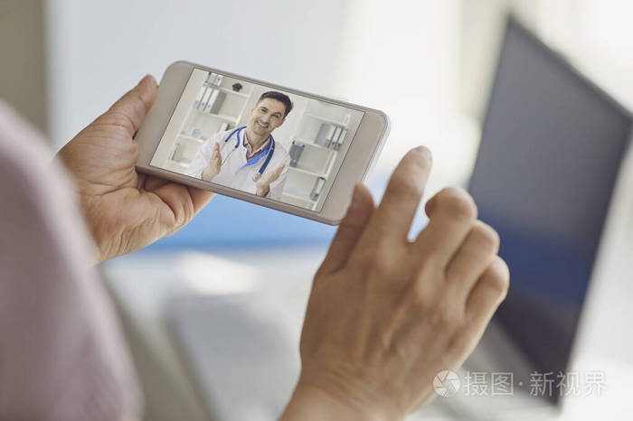 在线医生医生用坐在家里的移动笔记本电脑通过视频聊天咨询女性患者