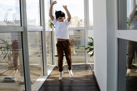 戴着虚拟现实眼镜的孩子.有限空间内的虚拟游戏.照片