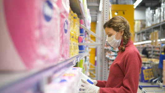 女孩戴着手套和医用口罩购买卫生纸大流行性冠状病毒超市防护设备