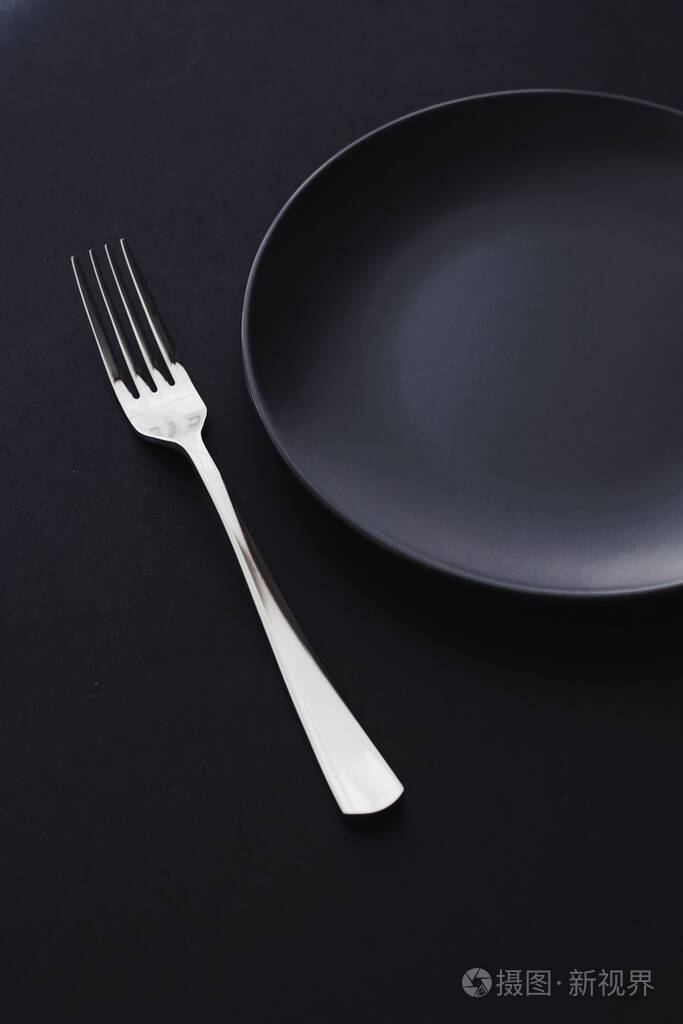 Empty plates and silverware on black background, premium tablewa