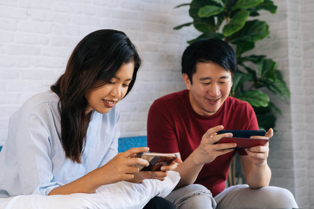 年轻男女朋友在家玩手机游戏.