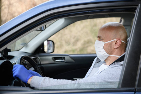 戴着医用防护面具开车的人。