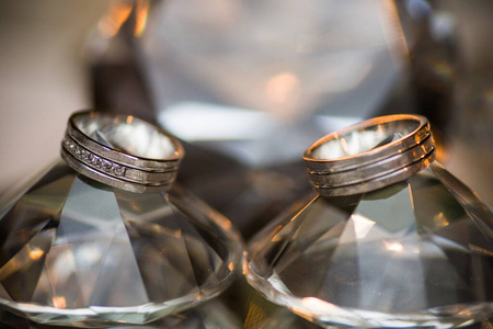 Wedding rings on a diamond shaped crystal background 