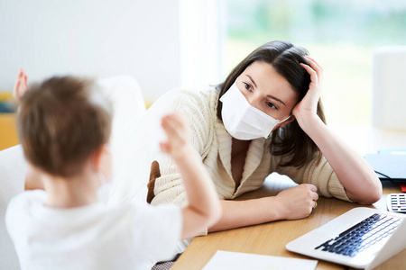 冠状病毒大流行期间，男孩和精疲力尽的母亲试图在家工作