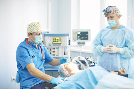 几位医生在工作时围在手术台上。手术室里的外科医生们在工作