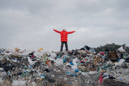 站在垃圾填埋场上的人，环境概念。