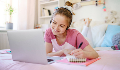 年轻女学生，床上有笔记本电脑，网络课程概念。