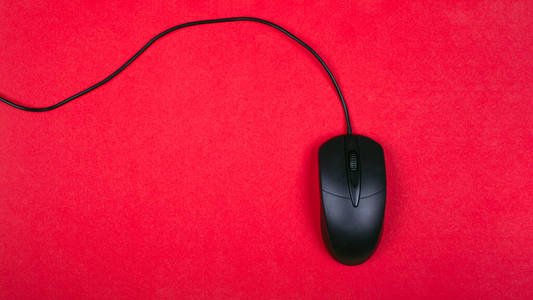 computer black mouse on red background top view
