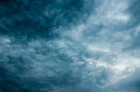 深蓝不祥的暴风云在头顶上密布。戏剧性的天空背景。水平方向。