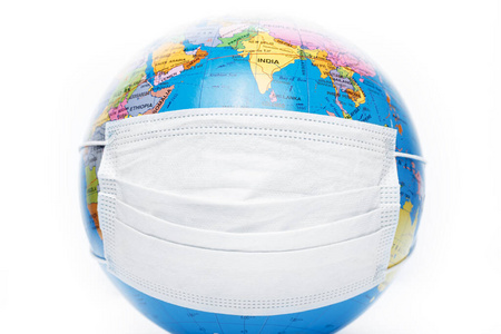 白底抗病毒外科防护面罩地球模型.保护地球行星的概念.照片