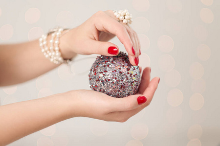 圣诞装饰，球在女性手中特写。白色背景。