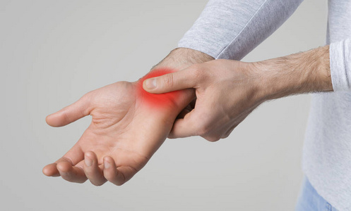 手腕骨头突出手腕疼痛概念.痛点用红色突出显示照片