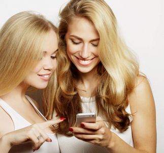 两位快乐的女性朋友在智能手机中分享社交媒体