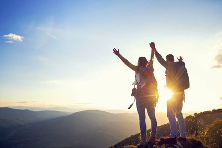 一对快乐的情侣,一对男女游客在日落时分在山顶户外徒步旅行照片