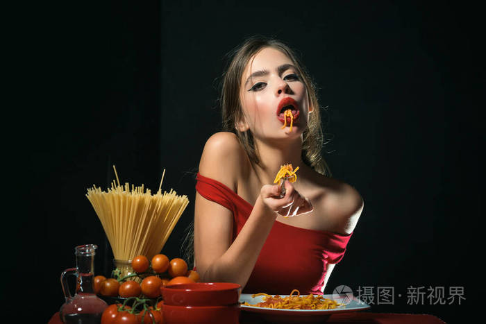 意大利式性感女人用手吃意大利面性感厨房女人拿着盘子里的意大利面条